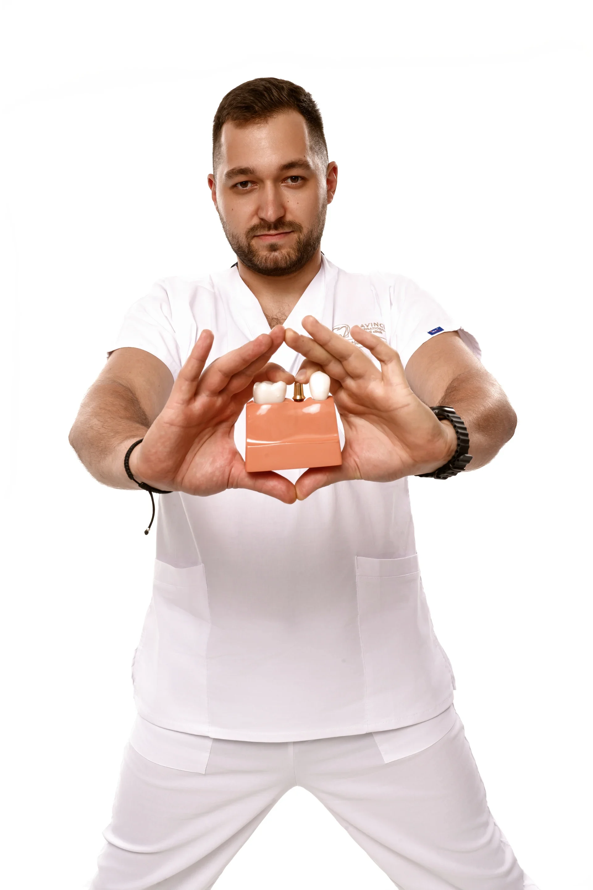 Medic prezentând un model de implant dentar