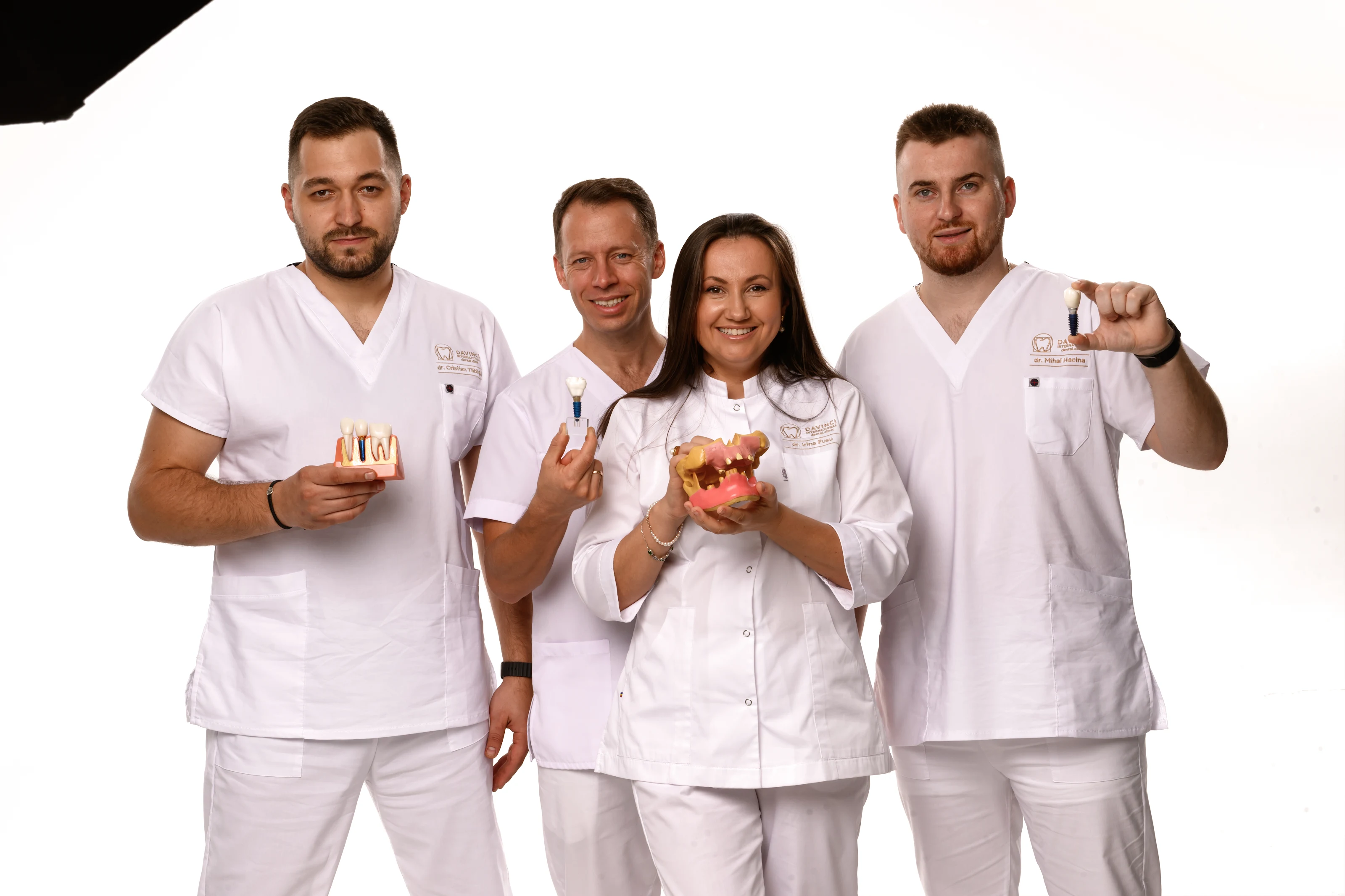 Patru membri ai echipei prezentând modele dentare